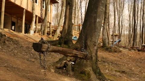 Empty swing swinging in forest. handmade wooden swing in the village Stock Footage 139718220