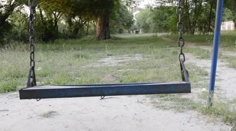 Empty swing swinging in the playground Stock Footage 58644699