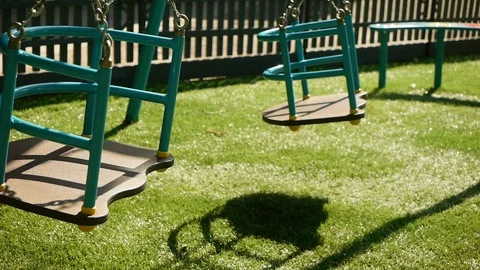 Empty Swing Swinging On The Playground On A Sunny Day Close-up Stock Footage 112382946