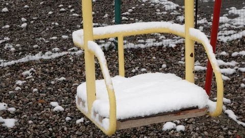 Empty swing swinging in the snow. An empty Playground Stock Footage 127651434