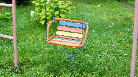 Empty swing swinging without children on the background of green grass in sum Video stock 154294453