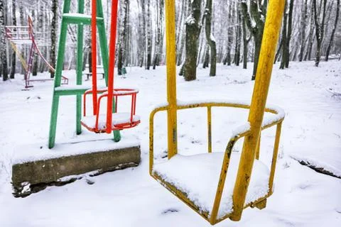 Empty swing in winter time with snow Stock Photos