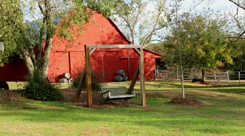 Empty swinging swing and red barn Video stock 33720560
