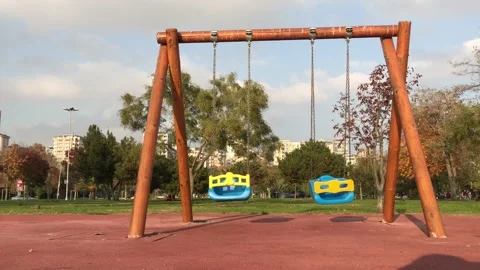 Empty swinging swing in children's park Stock Footage 144338211