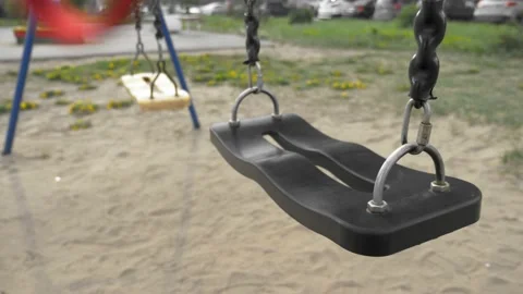 Empty swinging swing in the playground. closeup. copy space Vídeo Stock 130492677