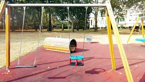 Empty swings with chains swaying at playground for child, moved from wind Stock Footage 131314331