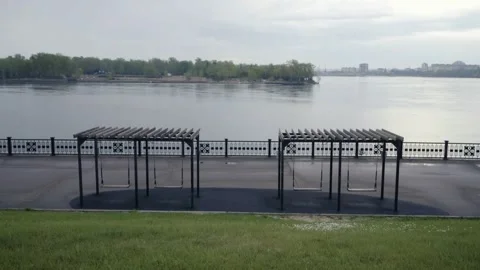 Empty swings on improved Yenisei River embankment early morning after rain .. Stock-Footage 335993588