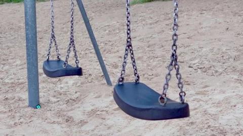 Empty swings moving in wind on sandy playground at Jurmala resort Latvia Stock Footage 344356057