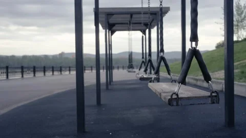 Empty swings on riverside promenade in early morning. Concept of loneliness.. Stock Footage 335993464