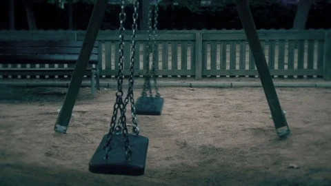 Empty swings swaying at playground Stock Footage 70751491
