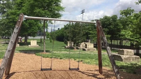 Empty swingset with dandelions blowing in the wind Stock Footage 78505672