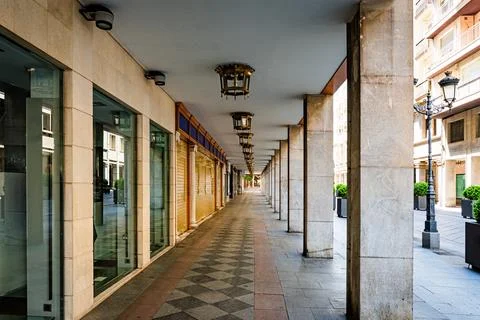 Empty, symmetrical arcade featuring stone columns and decorative lanterns. Stock Photos