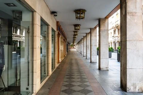 Empty, symmetrical arcade featuring stone columns and decorative lanterns. Stock Photos