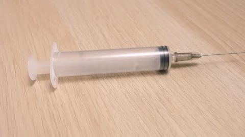 Empty Syringe and Needle on a Table With Camera Turning Around Stock Footage 88738112