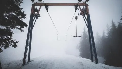 Empty t-bar lift in fog in mountains Stock Photos