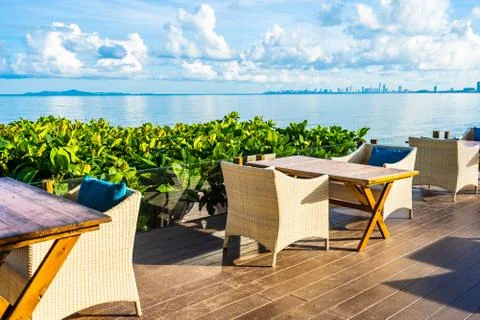Empty table and chair for dining set nearly sea ocean beach on white cloud bl Stock Photos