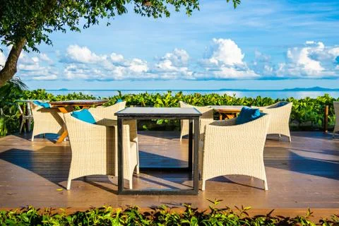 Empty table and chair for dining set nearly sea ocean beach on white cloud bl Stock Photos
