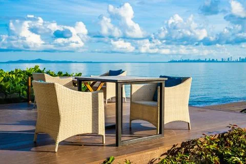 Empty table and chair for dining set nearly sea ocean beach on white cloud bl Stock Photos
