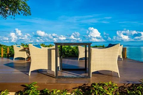 Empty table and chair for dining set nearly sea ocean beach on white cloud bl Stock Photos