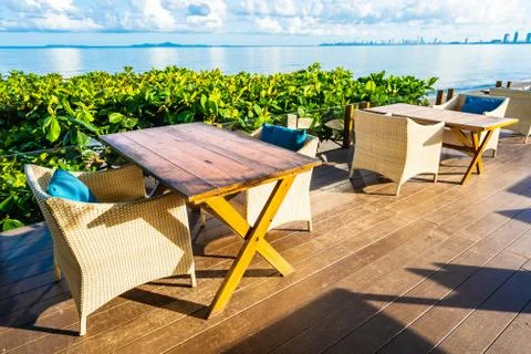 Empty table and chair for dining set nearly sea ocean beach on white cloud bl Stock Photos