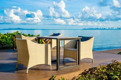 Empty table and chair for dining set nearly sea ocean beach on white cloud bl Stock Photos
