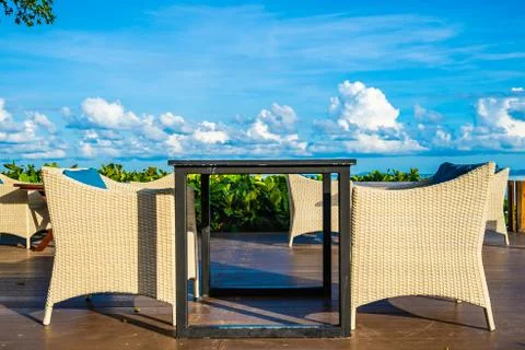 Empty table and chair for dining set nearly sea ocean beach on white cloud bl Stock Photos