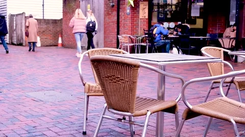 Empty Table And Chairs Outside A High Street Cafe With People Walking Past Stock Footage 162305682