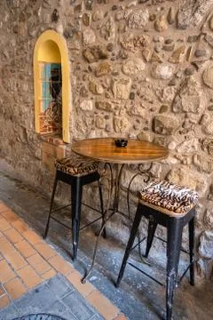 Empty table and chairs by the stone wall Stock Photos