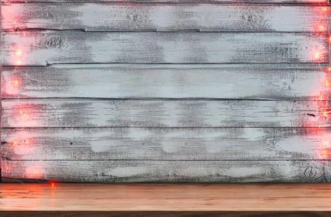 An empty table in front of a Christmas red garland of lights on a wooden rust Stock Photos