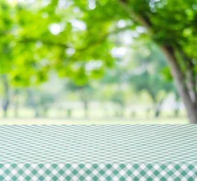 Empty table with green tablecloth over blur garden and bokeh background, fo.. Stock Photos