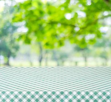 Empty table with green tablecloth over blur garden and bokeh background, fo.. Stock Photos