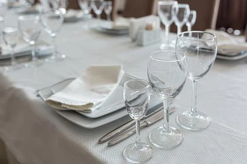 Empty table in a restaurant, served with cutlery, with a white cape Foto stock