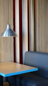 Empty table under a lamp in a cafe in brown and blue tones Stock Photos