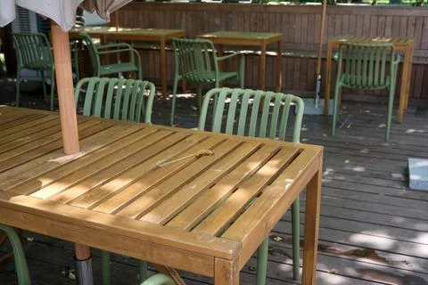 Empty tables await diners in a lively outdoor cafe setting Foto stock