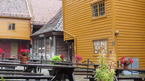 Empty tables between old wooden houses on a rainy day in Bergen Stock-Footage 289642140