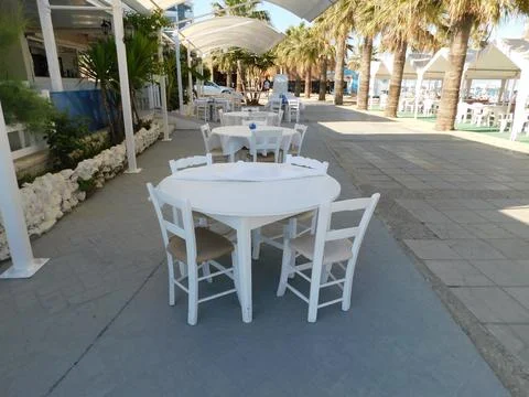 Empty tables in a cafe on the beach. Larnaca. Cyprus Stock Photos