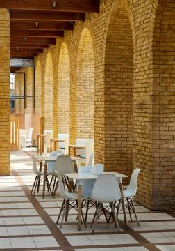 Empty tables in a loft-style cafe with brick columns Stock Photos