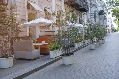 Empty tables of an outdoor summer cafe under a white canopy. No people in the Stock Photos