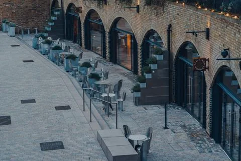 Empty tables outside Tom Dixon Studio in Coal Drops Yard, London, UK. Stock Photos