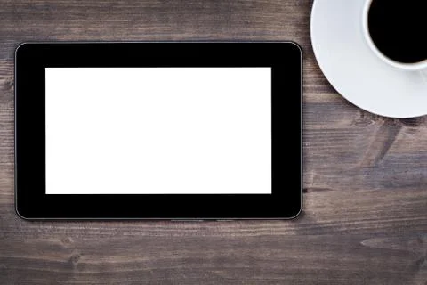 Empty tablet device with coffee cup on table Stock Photos