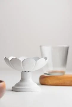 Empty tableware - white cakestand with a clear glass on white background fo.. Stock Photos