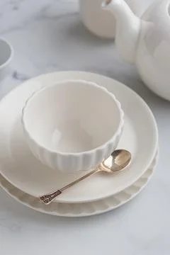Empty tableware - white plate, a bowl and a cup on white table as a backgroun Stock Photos