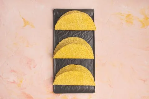 Empty taco shells on board on dark background Stock Photos