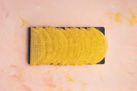 Empty taco shells on board on pink background Foto stock