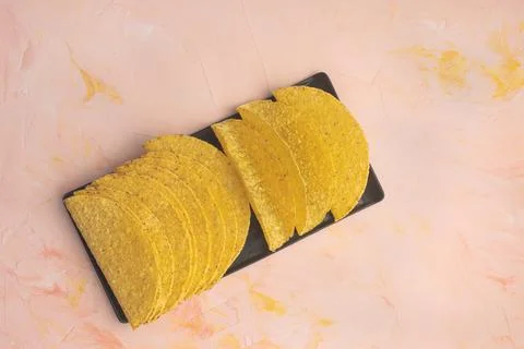 Empty taco shells on board on pink background Foto stock