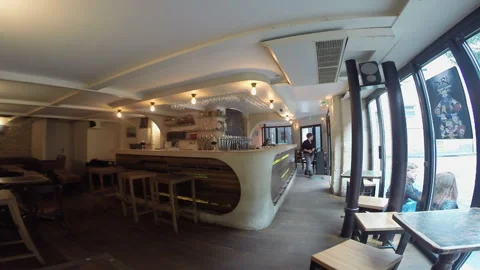 Empty Taproom Interior with Bartender Behind Counter and Patrons Outside Stock Footage 347263015