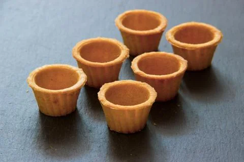 Empty tartlets for red or black caviar on dark gray stone background Stock Photos