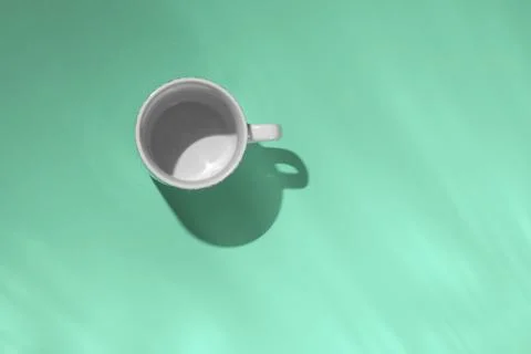 Empty tea cup on mint paper background. Coffee mug from above. Minimal concep Stock Photos
