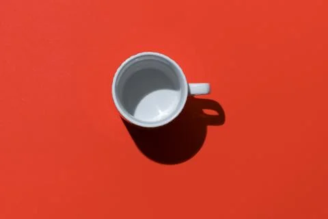 Empty tea cup on red paper background. Coffee mug from above. Minimal concept Stock Photos