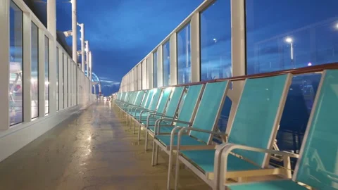 Empty Teal Lounge Chairs on Cruise Ship Promenade Deck at Night Stock Footage 345784965